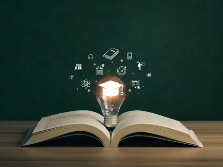 E-learning graduate certificate program concept. lightbulb on the book with graduation hat, and education icons. Internet education course degree, Idea of learning online class.Webinar Online Courses