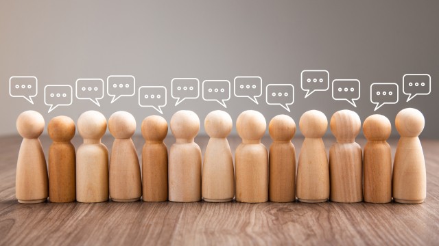 Mingle, discussion, chatting concept. Wooden figurine with speech bubble
